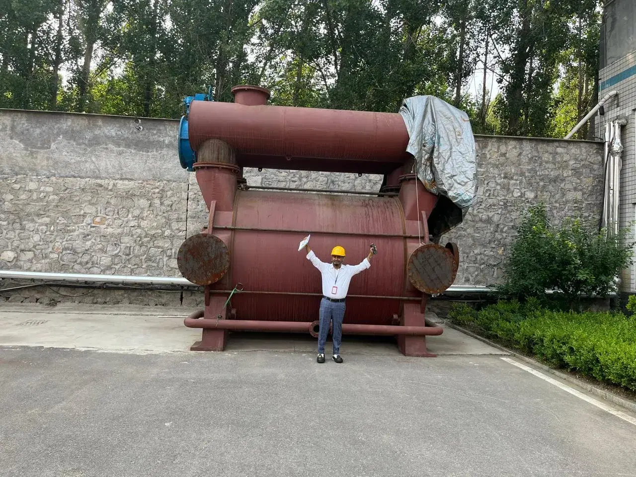 Engineer standing in front of a large liquid ring vacuum pump before shipment
